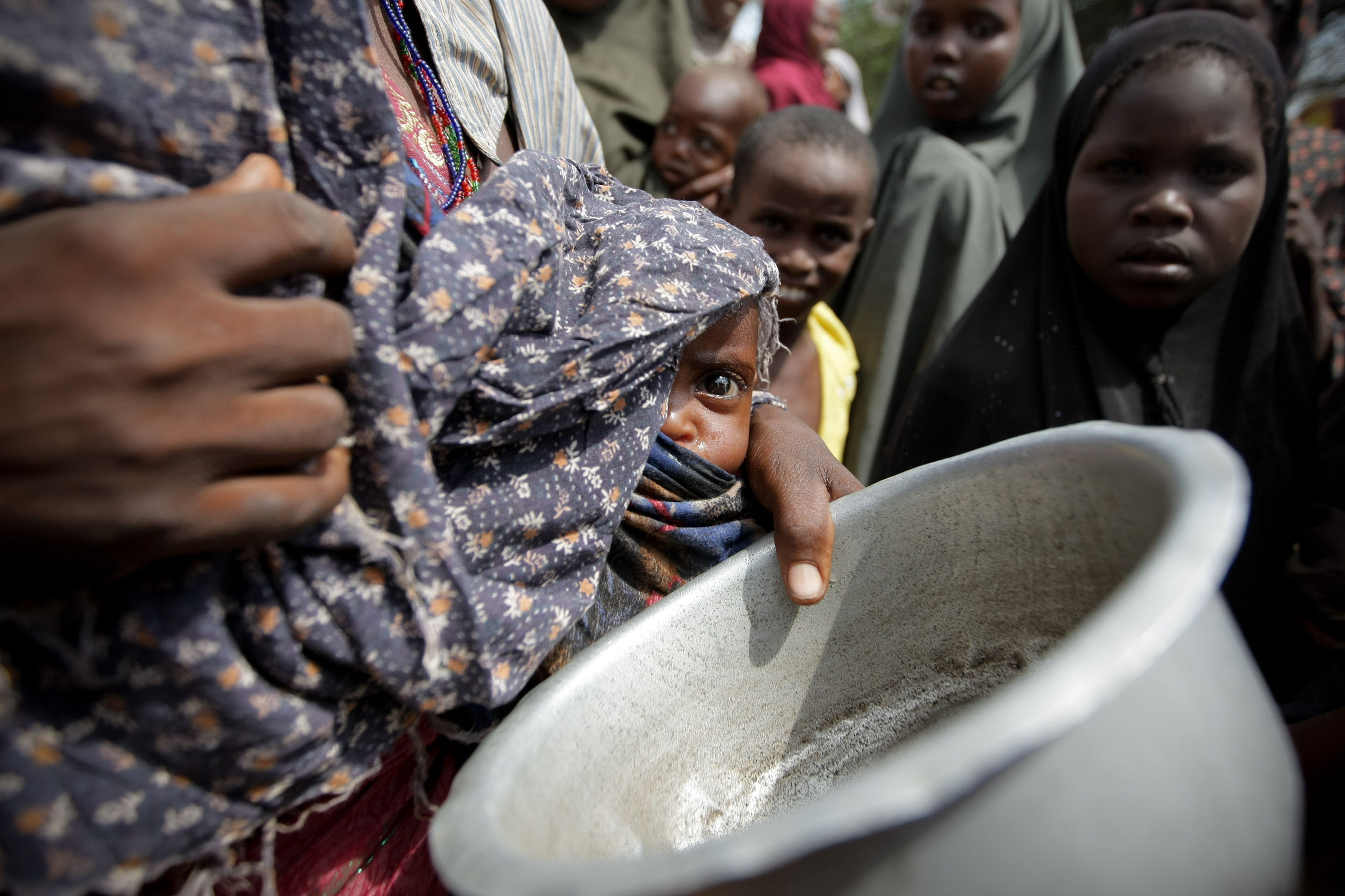 A woman holding her young malnourished baby queues for food at the Badbado camp for Internally Displaced Persons (IPDs). Famine has been declared in two regions of southern Somalia  southern Bakool and Lower Shabelle. The United Nations indicates that 3.7 million people across the country, thats nearly half of the Somali population, are now in crisis and in urgent need of assistance. An estimated 2.8 million of those are in the south.