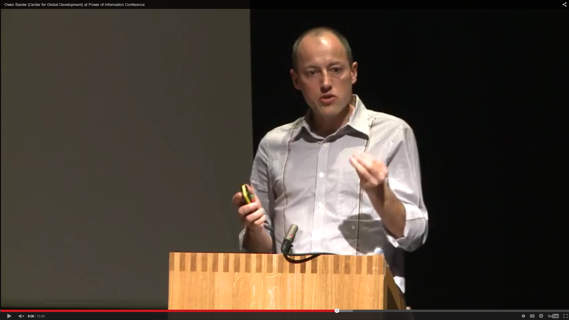 Owen Barder at a lectern, with a black backgroun. 2011