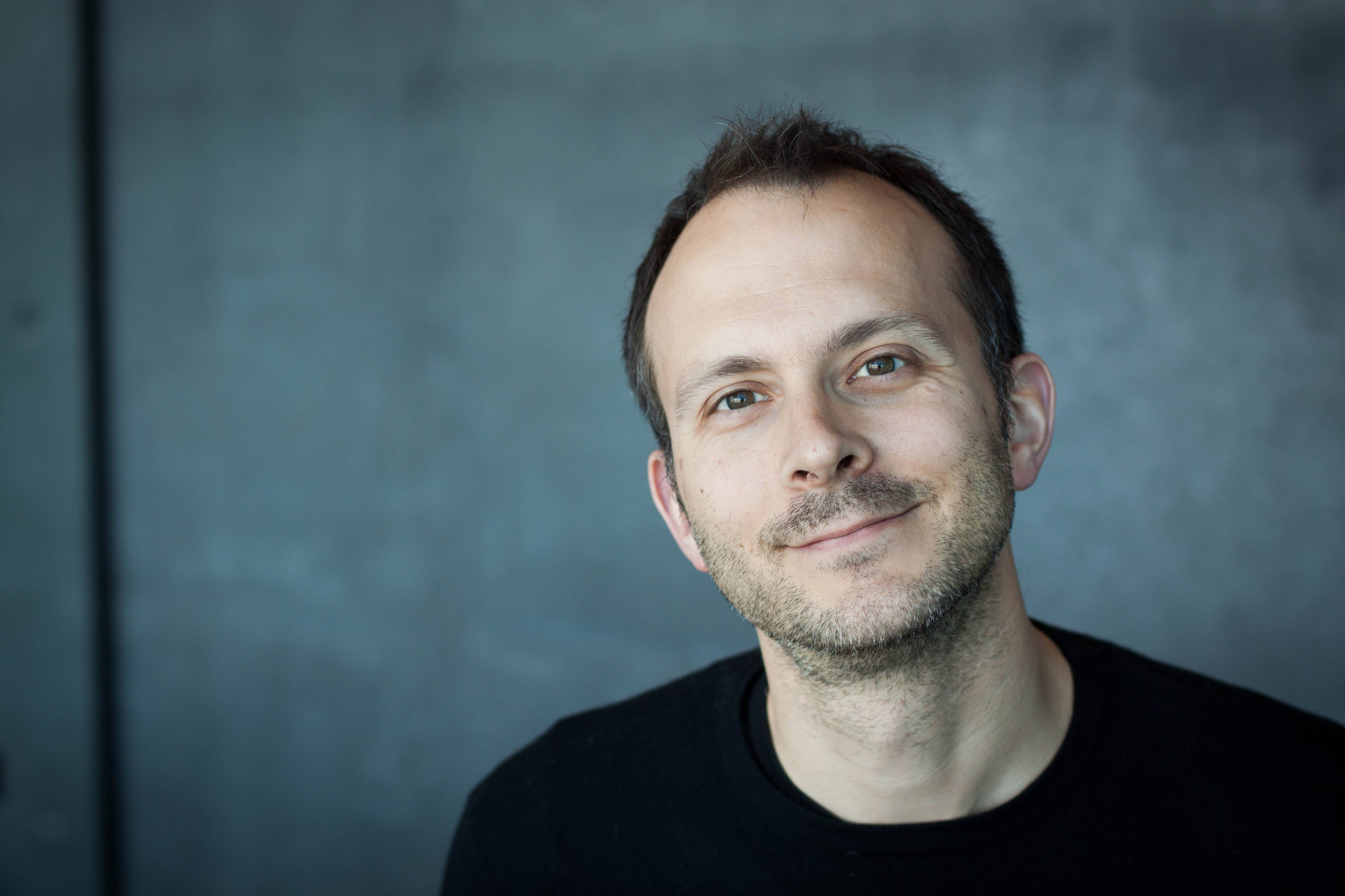 Tim Harford in front of a blue/grey screen