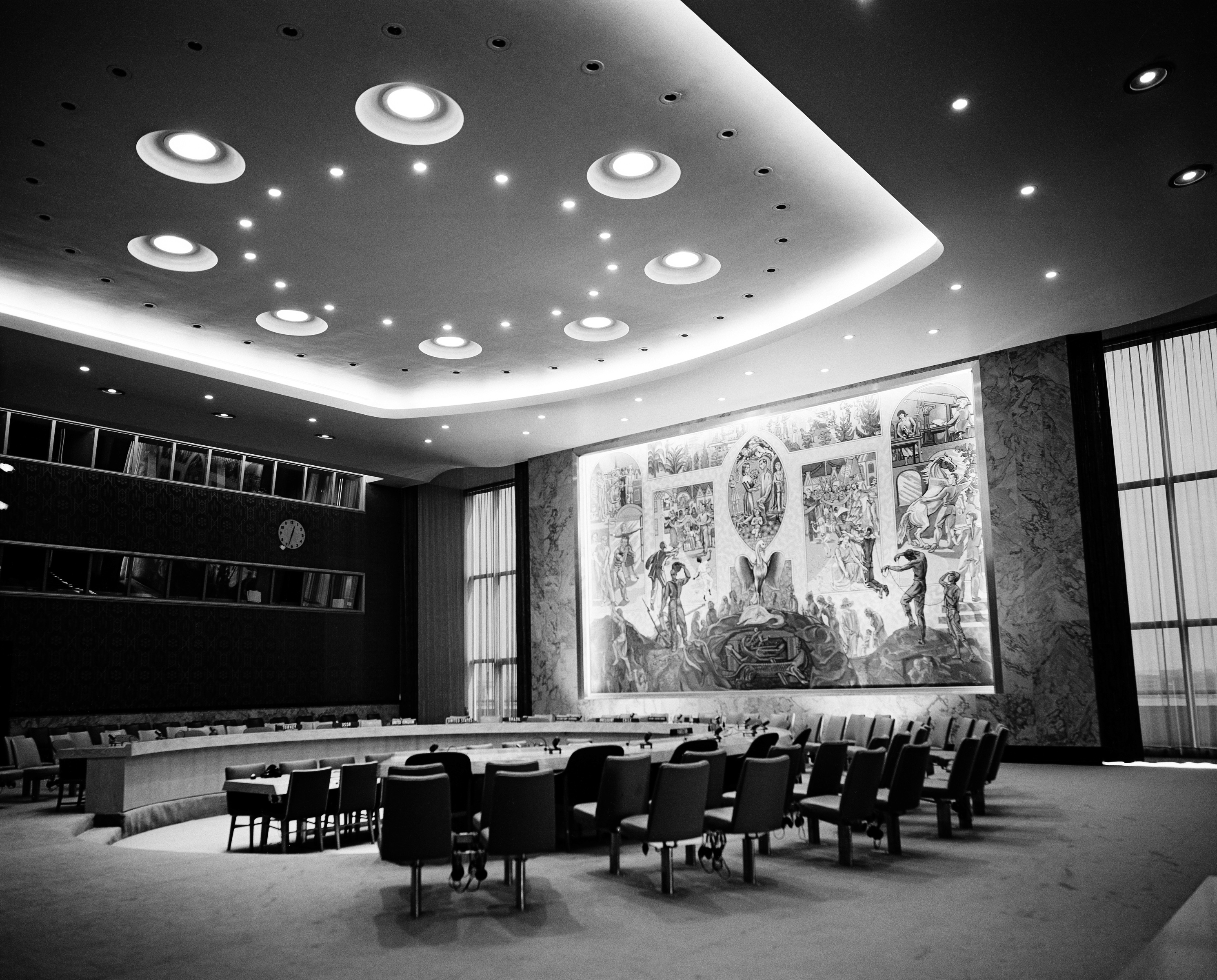 View of the Security Council chamber. This chamber, donated to the UN by Norway, was decorated by Arneberg, the mural is by Per Krogh. Besides the delegates, each council chamber accommodates 400 visitors and 120 press correspondents.