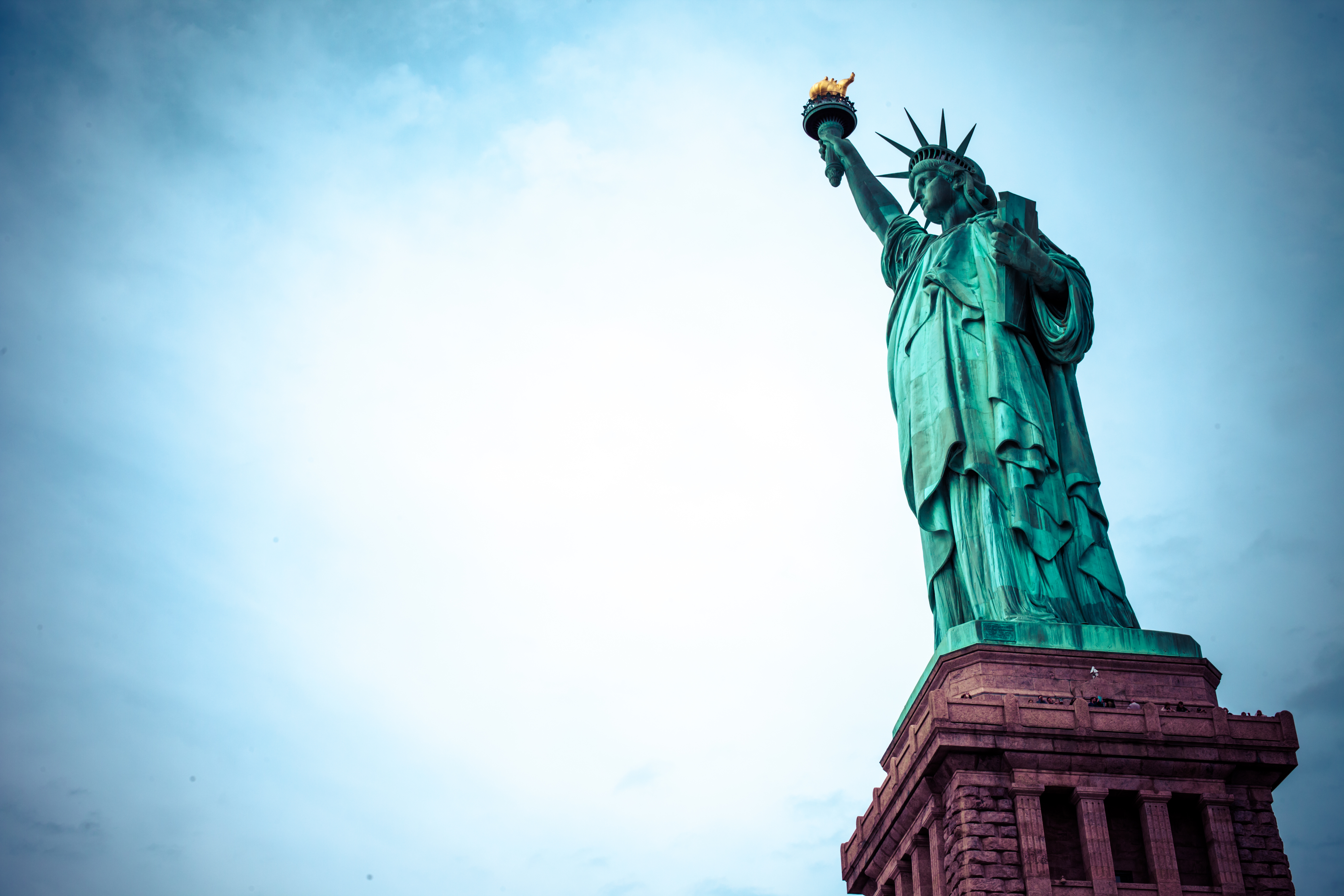 The Statue of Liberty, with blue sky and white cloud behind